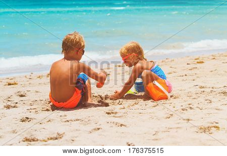 kids play with sand on summer tropical beach