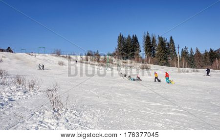 Slavske Ukraine - January 30 2017: Ski resort Slavske in Carpathians. People skiing on mountain slope. Sunny winter day.