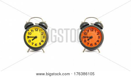 Closeup yellow alarm clock and orange alarm clock for decorate show a quarter to eight a.m. or 7:45 a.m. isolated on white background