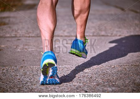 Running athlete during training outdoors in the summer on a sunny day.
