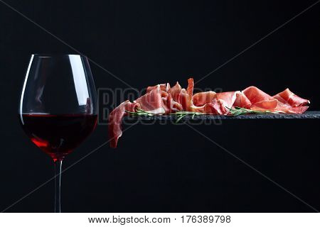 Prosciutto With Rosemary And Red Wine On A Black  Background