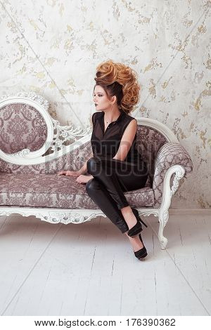 Fashion shiny makeup. Beauty woman with mohawk hairstyle. Blonde sexy model girl with long hair, long eyelashes, perfect skin. Creative unusual mohawk hairstyle. Skincare concept, model head. Rock style.