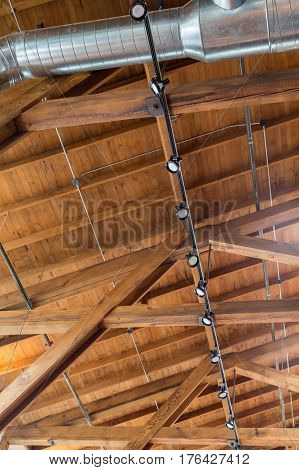 Ductwork and lights below a natural wood roof and rafters
