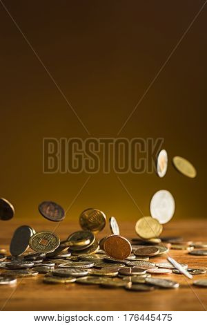 The silver and golden coins and falling coins on wooden table background