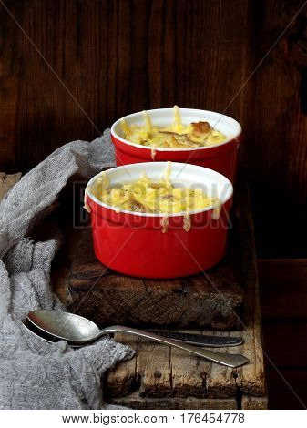 Casserole From Eggs, Bacon, Dried Tomatoes And Cheese In Red Ramekin On A Wooden Background