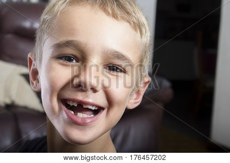 Closeup portrait of a young boy smiling with some teeth missing