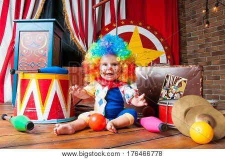 Little baby clown with red nose multi-colored wig in with balls.