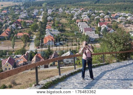 The girl is a photographer in the fortress of Sumeg. Hungary.