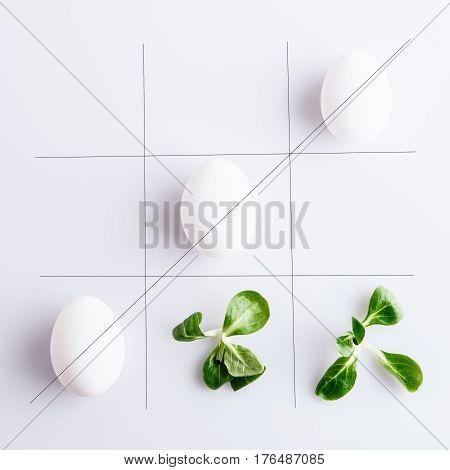 Tick-tack-toe from white eggs and corn leaves