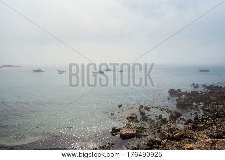 Island of Tabarca. Rocky coastline and crystal-clear turquoise water. Foggy weather in march. Province of Alicante. Spain