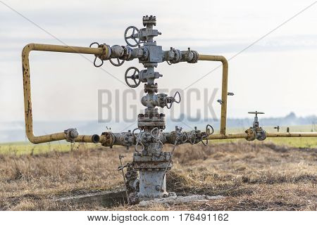 Old gas pipeline in the middle of the field. Extraction of gas from storage. Ukraine.