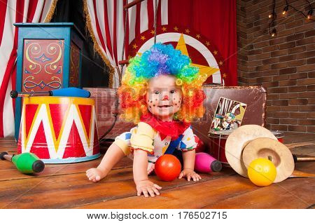 Little baby clown with red nose multi-colored wig in with balls.