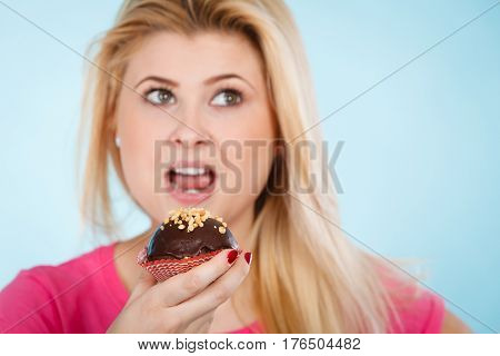 Woman Holding Chocolate Cupcake About To Bite