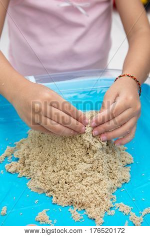 Child's Hand Close Up Playing Kinetic Sand