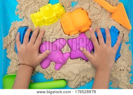 Child's Hand Close Up Playing Kinetic Sand