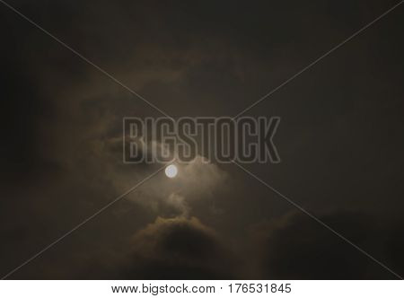 Sun shine in dark cloudy sky background.