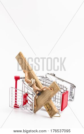 Shopping cart overturned with crucifix on the ground. Conceptual representation of commodification of religion loss of faith blasphemy.