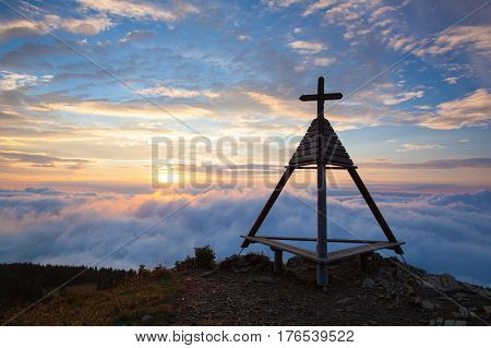 Wooden monument at sunrise. Gerlitzen Apls in Austria.