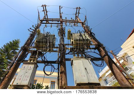 Rethymnon Island Crete Greece - June 23 2016: High voltage power pole with with a lot of wires and some transformators on the street of part Old Town in Rethymnon.