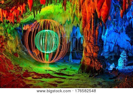 Cave interior abstract painted with colored light and a double sphere made with light on one side