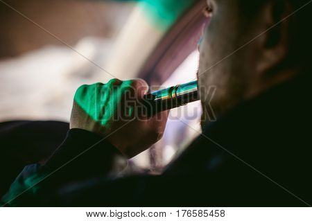 Young Vaper Man With Beard Vaping Mechanical Mod. Guy Smokes An Electronic Cigarette By Blowing A Sm