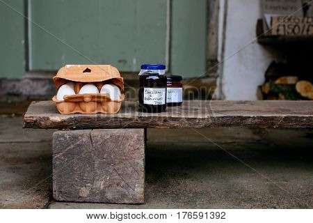 Eggs and homemade jam for sale on the porch of a house in small village of Lacock, England. Buyers are asked to pay for products into honesty box.