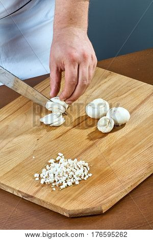 Cook cuts champignons for making a jelly chicken collection of culinary recipes
