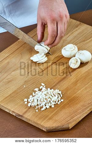 Cook cuts champignons for making a jelly chicken collection of culinary recipes