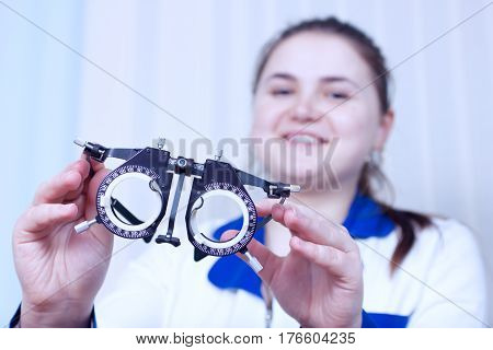 Close-up of optometrist holding messbrille glasses in ophthalmology clinic. Ophthalmic glasses for diopter detection.
