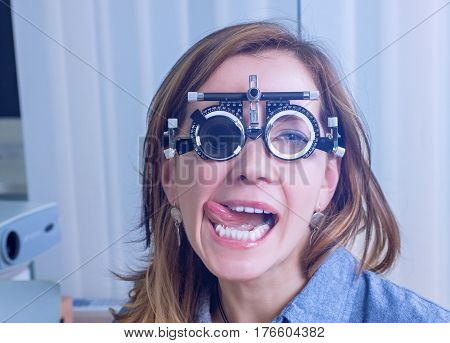 Girl woman in messbrille glasses in ophthalmology clinic. Ophthalmic glasses for diopter detection.