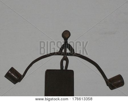 Miniature figure of weight lifter on a black base on gray background