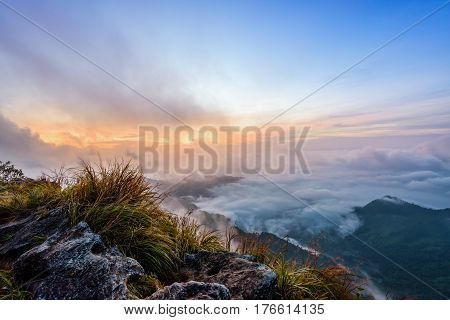 Beautiful landscape nature sunrise on peak mountain with sun cloud fog and bright colors of sky in winter at Phu Chi Fa Forest Park is a famous tourist attraction of Chiang Rai Province Thailand