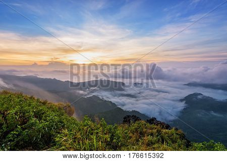 Beautiful landscape nature sunrise on peak mountain with sun cloud fog and bright colors of sky in winter at Phu Chi Fa Forest Park is a famous tourist attraction of Chiang Rai Province Thailand