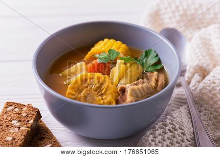 Puchero Soup With Corn And Parsley On Wooden Table