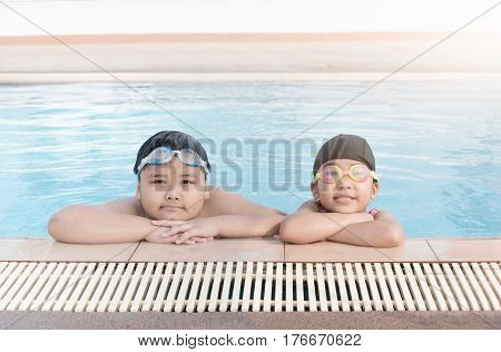 cute asian girl and fat boy smile in swimming pool concept sport and vacation
