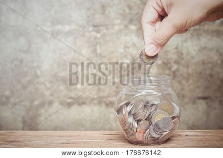 Close up woman's hand putting coin into the bottle