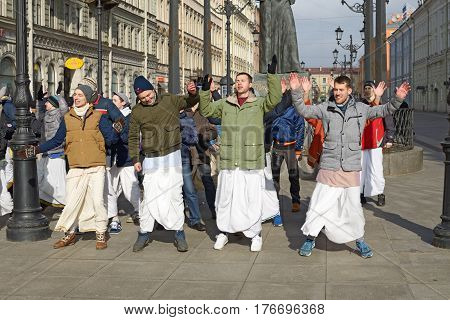 12.03.2017.Russia.Saint-Petersburg.On the street gathered followers of Lord Krishna.Young people are dancingcollecting alms and distributing sweets.
