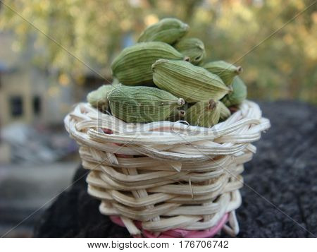 Fresh green cardamom in small bamboo basket