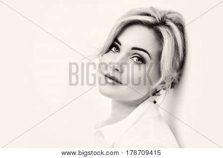 Portrait of a beautiful middle-aged woman in white blouse. Elegant businesswoman in the office.