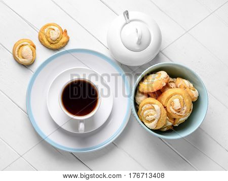 Gourmet golden freshy baked rolls with sugar powder served on lovely plates with coffee, topview