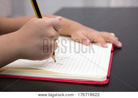 Close Of Children Hands Writing On Excercise Book