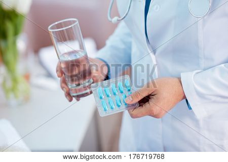 Doctor Holding Pills And Water