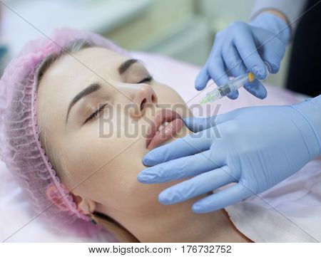 Woman gets injection in her face. Beauty woman giving injections. Young woman gets beauty facial injections in the cosmetology salon. Face aging injection. Aesthetic Medicine, Cosmetology