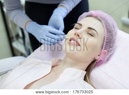 Woman gets injection in her face. Beauty woman giving injections. Young woman gets beauty facial injections in the cosmetology salon. Face aging injection. Aesthetic Medicine, Cosmetology