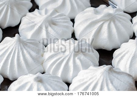 White mini meringues. Food background. Close uo