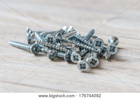 Countersunk wood screws on a wooden background.