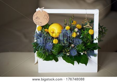 A spring bouquet in a white wooden box in the yellow-green spectrum. lemon.