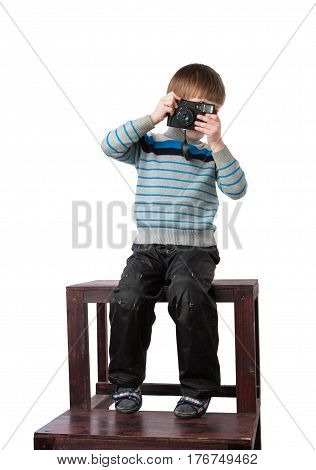 Young boy photographer taking pictures and playing with an old camera