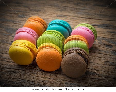 Colorful macarons on vintage pastel background. Macaron or Macaroon is sweet meringue-based confection.