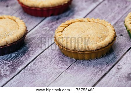 Apple pies of a round shape on a wooden table. close-up